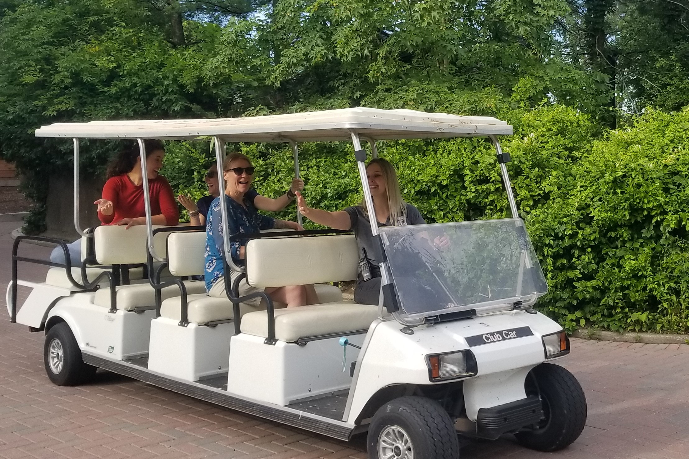 person driving three women on golf cart