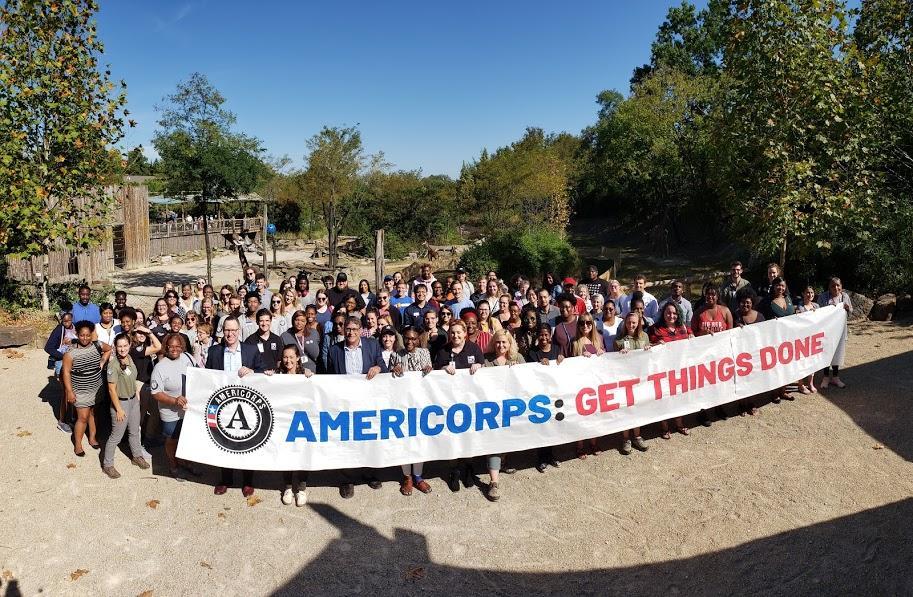 Americorps members holding sign at the zoo saying' Americorps: Get Things Done: