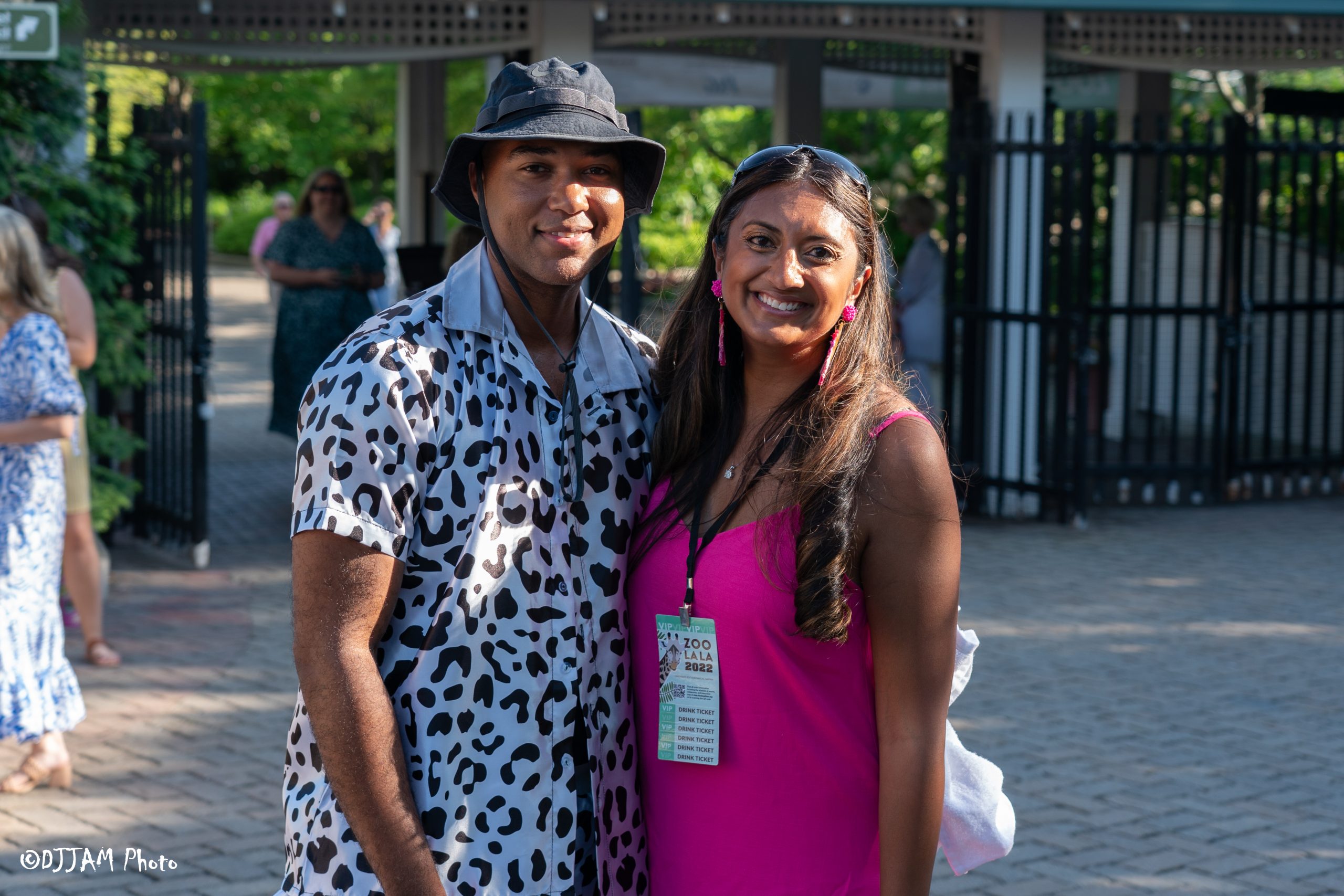 two people smiling for a photo at the zoos main entrance