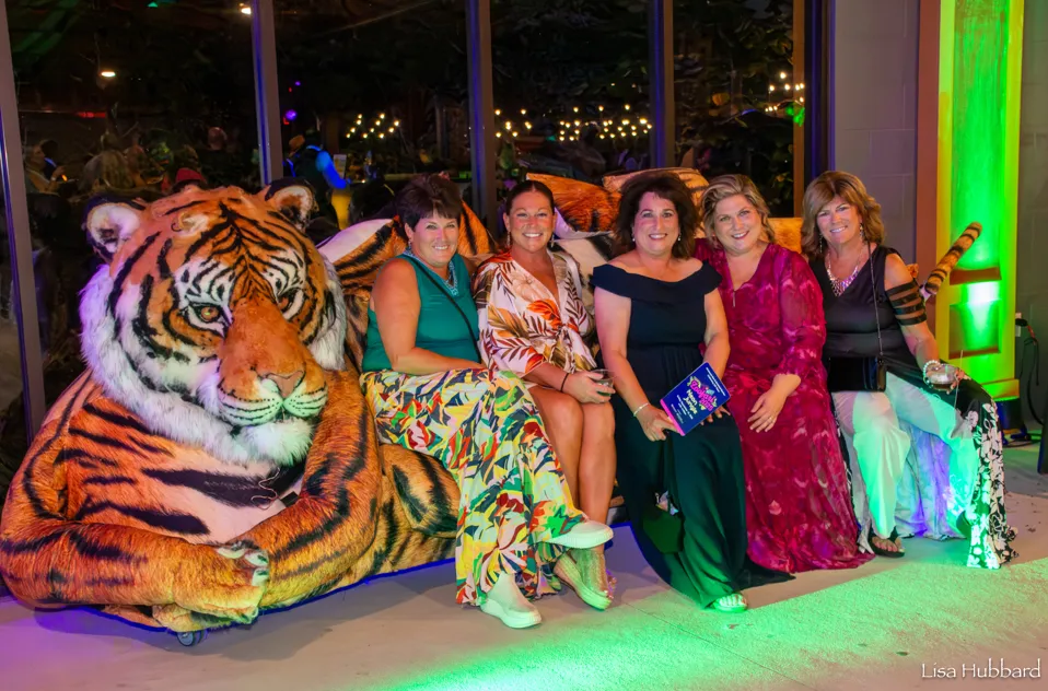 5 women posing on a tiger couch at the zoo
