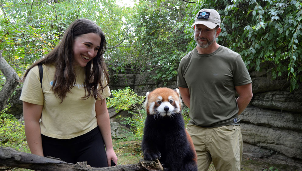 people standing with red panda