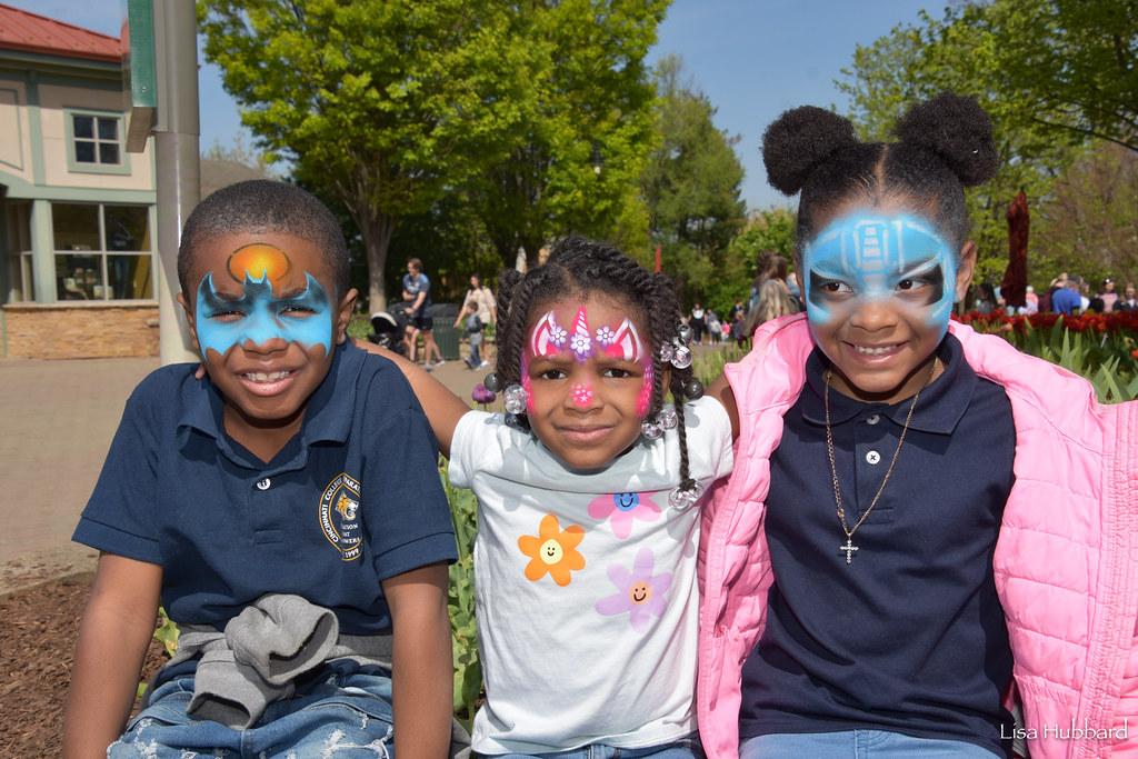 three small children with facepaint on at the zoo