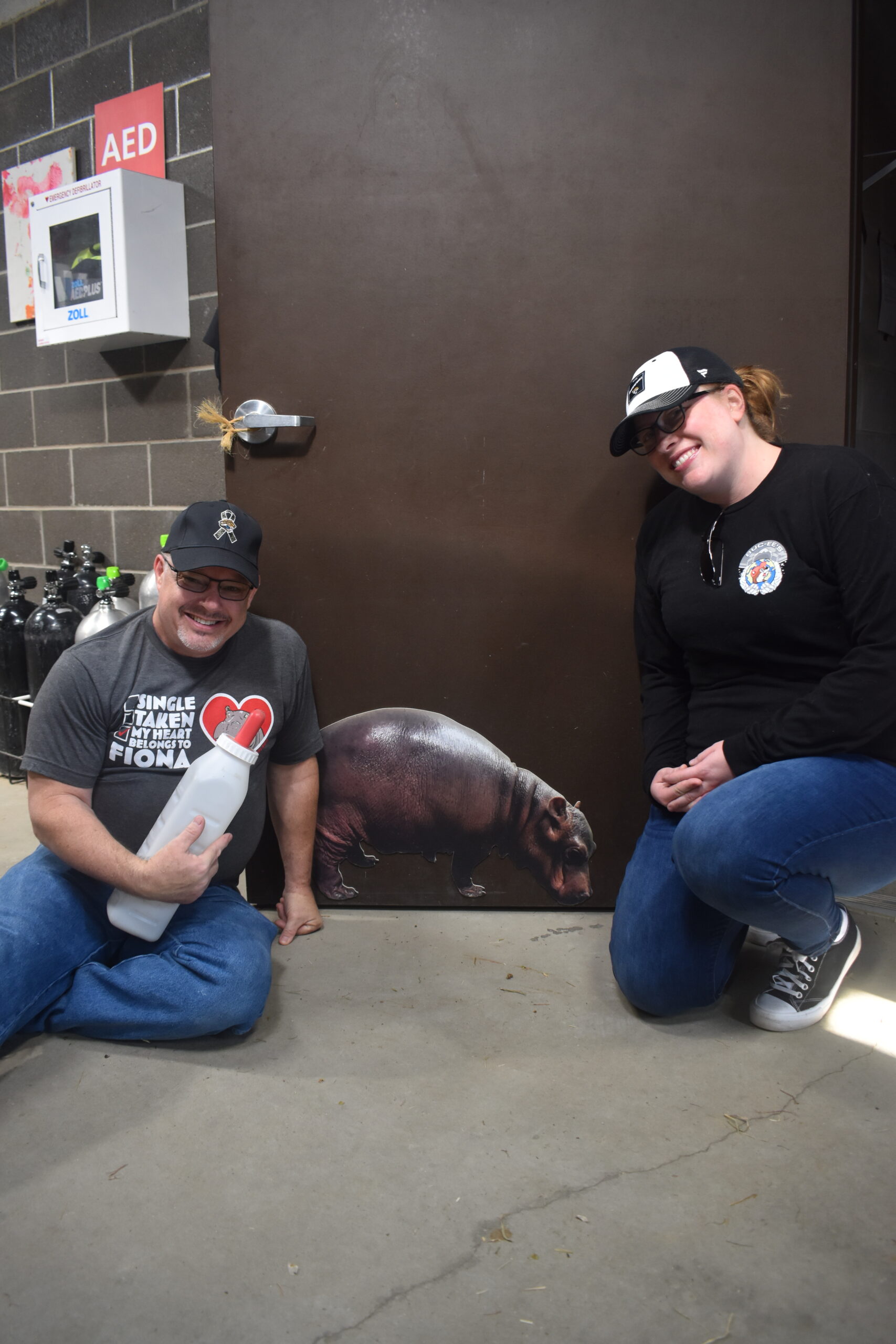 a man and a woman in the hippo barn posing for a photo