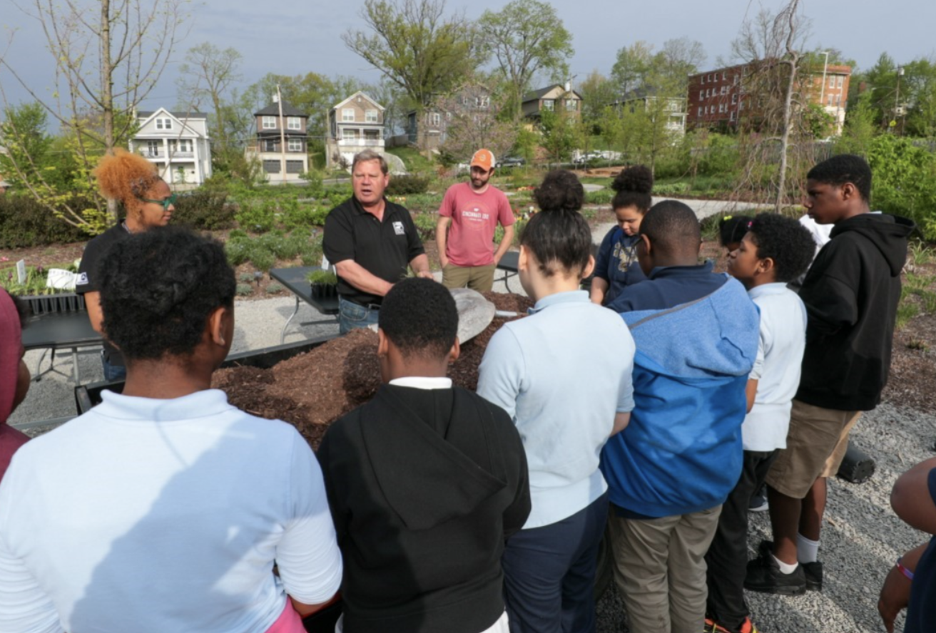 director of horticulture speaking to students in a garden