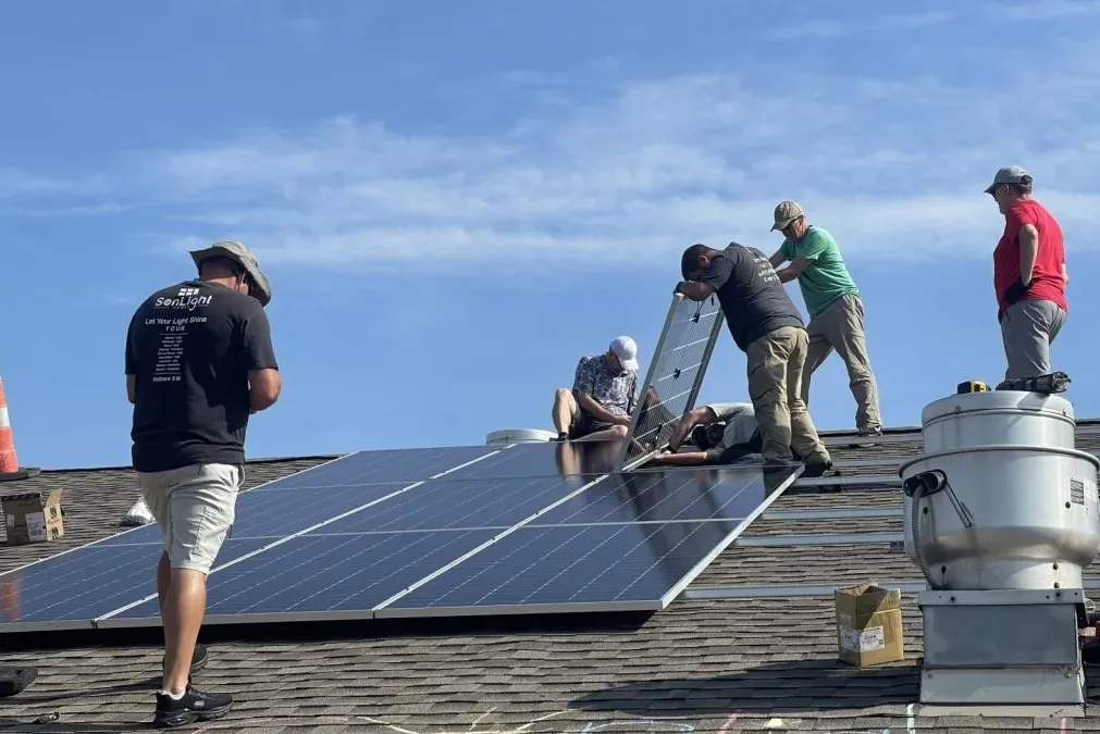 workers putting solar panels on the roof